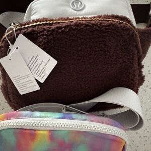 Three lululemon belt bags one white one furry brown and one multicolor. NWT